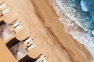 an aerial view of a beach with umbrellas at Exclusive Apartments in Thalassa Beach Resort in Vokolidha