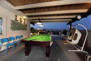 a patio with a pool table and chairs at לוז כנרת של רשת לב הגולן - וילה ו-4 צימרים מושלמים עם בריכה משותפת ליד הכנרת in Yavneʼel