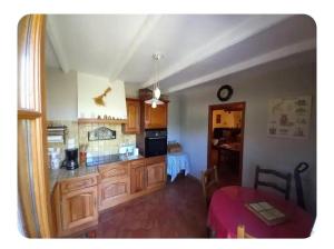 a kitchen with wooden cabinets and a table in a room at L'oliveraie in Correns