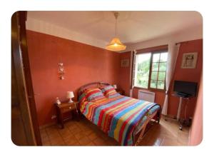a bedroom with a bed and a window and a television at L'oliveraie in Correns