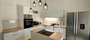 a kitchen with white cabinets and a stainless steel refrigerator at Superb house with pool in Saint-Raphaël in Saint-Raphaël