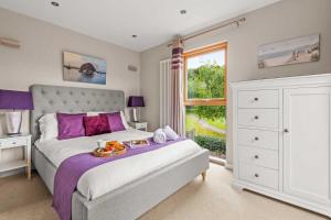 a bedroom with a bed with a tray of food on it at House 4 in Looe +27 photos