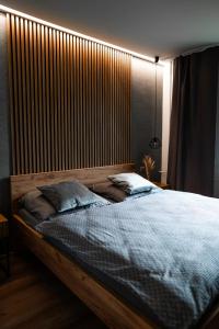a bedroom with a large bed with a wooden headboard at Apartmán BeVi in Loučná nad Desnou
