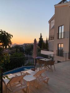 a patio with a table and chairs and an umbrella at REZEVICI BOUTIQUE VILLA in Petrovac na Moru