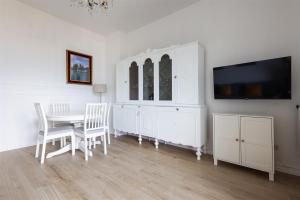 a dining room with a white cabinet and a table at IseoLakeRental - Casa Massimo in Lovere