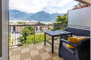 a balcony with a table and a view of the mountains at IseoLakeRental - Casa Massimo in Lovere