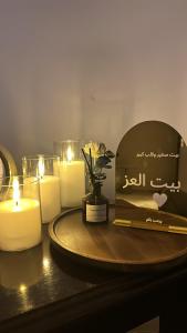 a table with candles and a tray with a plate with a box at بيت عز اقامة راقية in Aţ Ţunḑubāwī