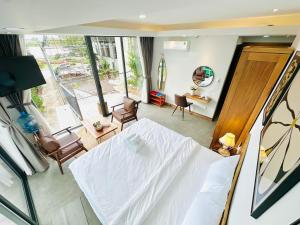 a bedroom with a white bed and a living room at 302MSNK Luxe Studio w Balcony & Kitchen in Can Tho +18 photos