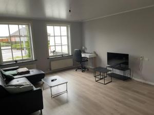 a living room with a couch and a table at Rent and Relax Geel in Geel