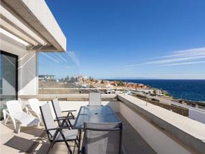 a balcony with chairs and a table and the ocean at Live El Poris Rodelas in Arico