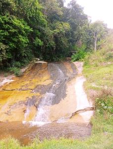 a stream of water on the side of a dirt road at Chalé Rosa Chalezinho da Serra in Natividade da Serra