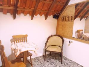 a room with two chairs and a table and a shelf at Chalé Rosa Chalezinho da Serra in Natividade da Serra +1 photo