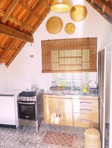 a kitchen with a stove and a sink at Chalé Rosa Chalezinho da Serra in Natividade da Serra