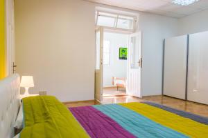 1 dormitorio con 1 cama con manta de arco iris en Sunny Apartment Anamaria Opatija, en Opatija