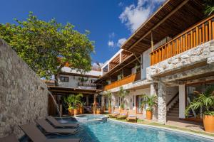 a pool with lounge chairs next to a building at Saluz Boutique Hotel in Jericoacoara
