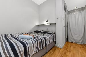 a bedroom with a bed with a striped blanket at Charming Modern 1bedroomFlat in the Heart Richmond in Richmond