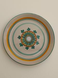 a plate with a flower design on a wall at da Mescia Maria in Morciano di Leuca +39 photos