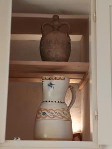 a vase sitting on a shelf in a cabinet at da Mescia Maria in Morciano di Leuca