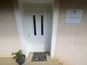 a white door of a house with a potted plant at LídRind porta in Zalaszentgrót