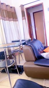 a room with a couch and a table and chairs at Marthe Appartement in Cotonou +14 photos
