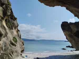 a view of a beach through a cave at Camino Bed and Breakfast Corme in Corme-Puerto