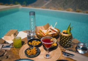 a table with food and drinks on a table by a pool at Divino Caldera in Akrotiri