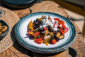 a plate of food with vegetables on a table at Divino Caldera in Akrotiri