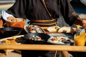 a person holding a tray of food on a table at Divino Caldera in Akrotiri