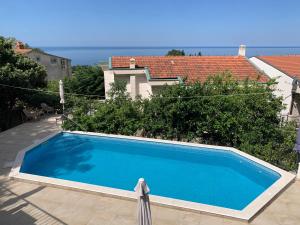 a large blue swimming pool in front of a house at REZEVICI BOUTIQUE VILLA in Petrovac na Moru