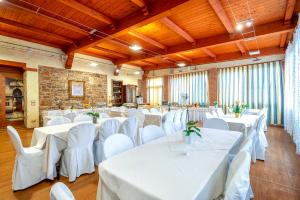 ein Festsaal mit weißen Tischen und weißen Stühlen in der Unterkunft Hotel Fertilia in Fertilia
