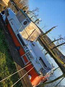 an orange boat is sitting in the water at bateau tinkerbell in Labastide-dʼAnjou