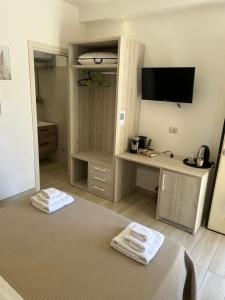 a room with a bed and a desk with a television at Mary's rooms in Parghelia