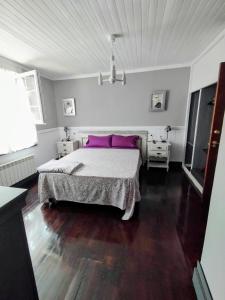 a bedroom with a large bed with purple pillows at hotel el candano in Pravia +18 photos
