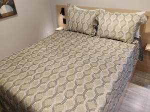 a large bed in a bedroom with a bedspread at Novo studio sofisticado ao lado do Allianz Parque in Sao Paulo