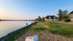 a house on the shore of a body of water at Le Cocon de bord de Seine in La Mailleraye-sur-Seine