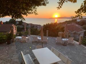 a table and chairs with the sunset in the background at REZEVICI BOUTIQUE VILLA in Petrovac na Moru