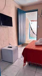 a bathroom with a sink and a bed and a window at Suítes Benfica in Arraial d'Ajuda