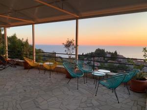 a patio with chairs and tables and a view of the ocean at REZEVICI BOUTIQUE VILLA in Petrovac na Moru