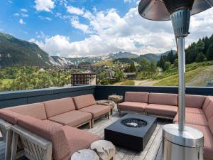 a balcony with a couch and a table and a view at Magnifique appartement 6 pièces avec jacuzzi à Courchevel, proche des pistes - FR-1-562-79 in Courchevel