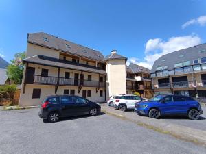 three cars parked in a parking lot in front of a building at T3 Duplex 6 Pers, Parking, Cuisine Équipée, Proche St Lary - FR-1-457-283 in Vielle-Aure