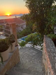 a sunset view of a house with a fence at REZEVICI BOUTIQUE VILLA in Petrovac na Moru