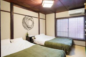 a room with two beds and a window at Tokyo Ninja 屋敷 in Tokyo