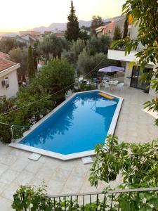 a large blue swimming pool in a yard at REZEVICI BOUTIQUE VILLA in Petrovac na Moru
