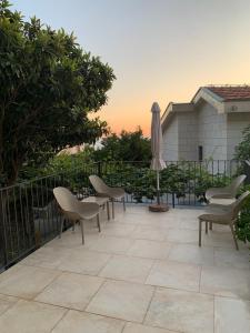 a patio with a table and chairs and an umbrella at REZEVICI BOUTIQUE VILLA in Petrovac na Moru
