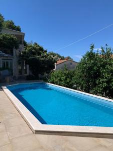 a blue swimming pool in a yard at REZEVICI BOUTIQUE VILLA in Petrovac na Moru