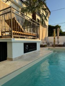 a swimming pool next to a house with a balcony at Noa Apartments Pool & Spa in Kragujevac +7 photos