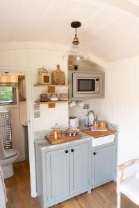 a kitchen with white cabinets and a microwave at Whitbourne farm in Corsley +24 photos