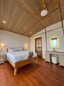 a bedroom with a bed and a ceiling fan at Seaweed Village Deluxe Room in Semporna