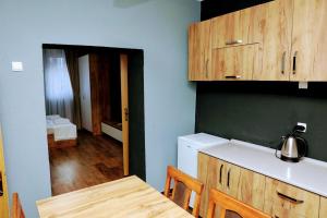 eine Küche mit Tisch und Spüle und eine Küche mit einem Zimmer in der Unterkunft Hotel Ari in Prizren + 155 Fotos