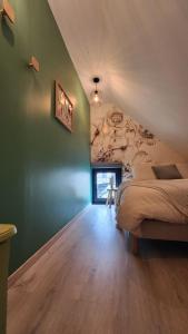 a bedroom with a bed and a green wall at Le Cocon de bord de Seine in La Mailleraye-sur-Seine